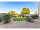 Landscaped backyard with artificial turf and desert landscaping at 41844 W Rosa Dr, Maricopa, AZ 85138