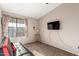 Bright bedroom with large window, plush couch, and wall-mounted TV at 5416 E Glencove St, Mesa, AZ 85205