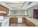 Galley kitchen with wood cabinets, granite countertops and tile floor at 5530 N 47Th Ave, Glendale, AZ 85301