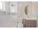 Updated bathroom with gray vanity, tiled shower and oval mirror at 6443 E Alder Ave, Mesa, AZ 85206