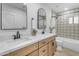 Modern bathroom with double vanity, patterned tile, and a bathtub at 6613 W Sweetwater Ave, Glendale, AZ 85304