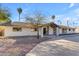 Single-story home with white brick exterior, landscaped yard, and a long driveway at 6613 W Sweetwater Ave, Glendale, AZ 85304