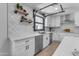 Modern kitchen features white cabinets, a farmhouse sink, and stainless steel appliances at 6613 W Sweetwater Ave, Glendale, AZ 85304