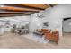 Open concept living room with a modern fireplace, wood beams, and stylish furniture at 6613 W Sweetwater Ave, Glendale, AZ 85304