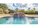 Relaxing pool with a natural rock waterfall feature, surrounded by greenery at 6613 W Sweetwater Ave, Glendale, AZ 85304
