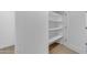 White storage room with three shelves and wood-look flooring at 6613 W Sweetwater Ave, Glendale, AZ 85304