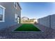 Artificial turf backyard with gravel border and a view of the home's side elevation at 9814 E Sunspot Dr, Mesa, AZ 85212