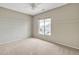 Bright bedroom with large window, ceiling fan, and neutral decor at 1036 E Oak Rd, San Tan Valley, AZ 85140