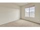 Simple bedroom with large window, ceiling fan, and neutral decor at 1036 E Oak Rd, San Tan Valley, AZ 85140