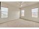 Spacious bedroom with three windows, ceiling fan, and neutral decor at 1036 E Oak Rd, San Tan Valley, AZ 85140