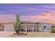 Mid-century modern home with updated facade, desert landscaping, and sunset views at 10922 W Granada Dr, Sun City, AZ 85373