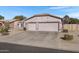 Two-car garage with driveway and desert landscaping at 1102 E Bartlett Way, Chandler, AZ 85249