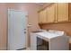 Laundry room with washer, dryer, and upper cabinets at 1102 E Bartlett Way, Chandler, AZ 85249