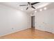 Bedroom with ceiling fan, wood floor, and access to bathroom at 11030 W Pleasant Valley W Rd, Sun City, AZ 85351