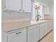 White kitchen cabinets, double sink, dishwasher, and tile floors at 11030 W Pleasant Valley W Rd, Sun City, AZ 85351
