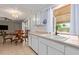 Kitchen with white cabinets, double sink, and window overlooking backyard at 11030 W Pleasant Valley W Rd, Sun City, AZ 85351