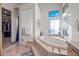 Bathroom featuring a luxurious soaking tub and glass block shower enclosure at 148 N La Barge Rd, Apache Junction, AZ 85119