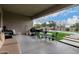 Covered patio with seating area, grill, and view of pool and backyard at 14918 W Escondido Dr, Litchfield Park, AZ 85340
