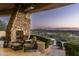Outdoor patio with stone fireplace, seating area, and stunning sunset views at 15402 E Crested Butte Trl, Fountain Hills, AZ 85268