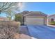 One-story house with a beige exterior, two-car garage, and well-manicured landscaping at 1643 E Bishop Dr, Casa Grande, AZ 85122