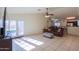 Bright living room with a brown sofa, tile floors, and French doors leading to the backyard at 1643 E Bishop Dr, Casa Grande, AZ 85122