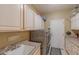 Convenient laundry room with washer, dryer, and cabinets at 18031 N Timber Ridge Dr, Surprise, AZ 85374