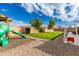 Landscaped backyard featuring a grassy lawn, playground, and swing set at 18346 W Coolidge St, Goodyear, AZ 85395