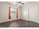 Well-lit bedroom with orange curtains and wood-look flooring at 18346 W Coolidge St, Goodyear, AZ 85395