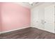 Cozy bedroom with pink wall and wood-look flooring at 18346 W Coolidge St, Goodyear, AZ 85395