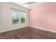 Charming bedroom with pink accent wall and wood-look flooring at 18346 W Coolidge St, Goodyear, AZ 85395