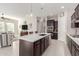 Open kitchen with island, dark cabinets and stainless steel appliances at 20771 W Windsor Blvd, Buckeye, AZ 85396