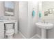 Small powder room with pedestal sink and white toilet at 20771 W Windsor Blvd, Buckeye, AZ 85396