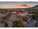 Aerial view of a single-story home with a pool and large backyard at sunset at 20918 E Orchard Ln, Queen Creek, AZ 85142