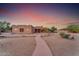 Southwest style home with a welcoming walkway, desert landscaping, and a beautiful sunset at 20918 E Orchard Ln, Queen Creek, AZ 85142