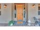 Rustic wooden front door with a welcoming mat and lanterns on either side at 20918 E Orchard Ln, Queen Creek, AZ 85142
