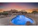 Inviting kidney shaped pool with a water feature, surrounded by a private fenced backyard at 20918 E Orchard Ln, Queen Creek, AZ 85142