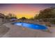 Relaxing kidney-shaped pool with water features at sunset at 20918 E Orchard Ln, Queen Creek, AZ 85142