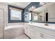 Bathroom with double vanity, soaking tub, and blue walls at 22230 N Daniel Dr, Maricopa, AZ 85138