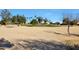 View of a sandy golf course with mature trees and homes in the background at 22619 N Las Lomas Ln, Sun City West, AZ 85375