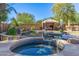 Relaxing hot tub and patio area with a pool in the background at 2415 W Desperado Way, Phoenix, AZ 85085