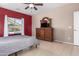 Bedroom with gray bedding, red accent wall, and a view of the pool at 28452 N Crimm Rd, San Tan Valley, AZ 85143