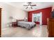 Spacious bedroom with a gray comforter and red accent wall at 28452 N Crimm Rd, San Tan Valley, AZ 85143