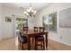 Dining room with a wood table and bench, chandelier, and backyard access at 28452 N Crimm Rd, San Tan Valley, AZ 85143