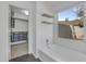 Bright bathroom featuring a tub under a window, tile flooring, and closet access at 3024 E Siesta Ln, Phoenix, AZ 85050