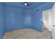 This bedroom features blue walls, neutral carpet and staircase access at 3024 E Siesta Ln, Phoenix, AZ 85050