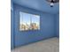 Bright blue bedroom has neutral carpet, ceiling fan, and large windows at 3024 E Siesta Ln, Phoenix, AZ 85050