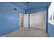 Well-lit blue bedroom features neutral carpet, white trim, and a ceiling fan at 3024 E Siesta Ln, Phoenix, AZ 85050