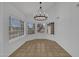 Bright dining room with large windows, chandelier, and neutral tile flooring at 3024 E Siesta Ln, Phoenix, AZ 85050