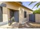 Welcoming front entrance featuring a secure gate, grey door, and desert landscaping at 3024 E Siesta Ln, Phoenix, AZ 85050