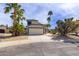 Inviting single-Gathering home with a two-car garage and desert landscaping featuring mature palm trees at 3024 E Siesta Ln, Phoenix, AZ 85050